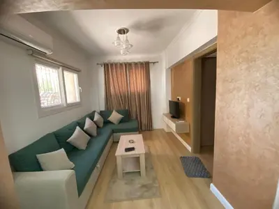 a living room with a green couch and a table at CC Luxurious Apartment in Hurghada