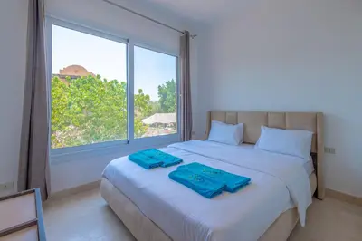 a bedroom with a bed with blue towels on it at Cozy apartment with a pool in South Marina-Elgouna in Hurghada