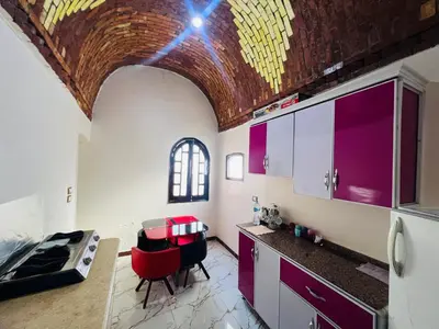 a kitchen with purple cabinets and a brick ceiling at private home lucky seven in Luxor