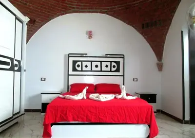 a bedroom with a red bed with two people on it at private home lucky seven in Luxor