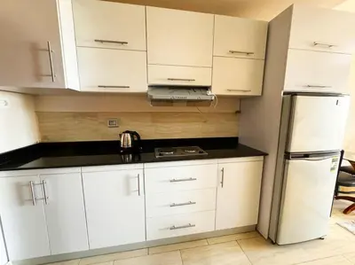 a kitchen with white cabinets and a refrigerator at Hula Hula piece of the sea in Hurghada