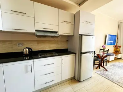 a kitchen with white cabinets and a refrigerator at Hula Hula piece of the sea in Hurghada