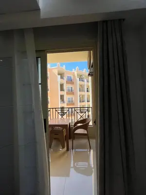 a balcony with a table and a chair and a building at Juliana Beach Aqua park in Hurghada