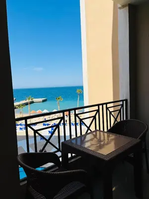 a table and chairs on a balcony with the ocean at Juliana Beach Aqua park in Hurghada