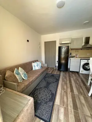 a living room with a couch and a kitchen at Camelgila Appartment Royal Residence in Port Ghalib