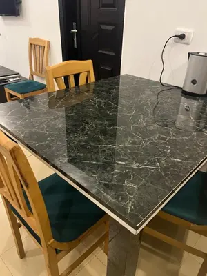 a black marble dining table with chairs in a room at Two Bedroom Apartment in Lilly Land in Hurghada