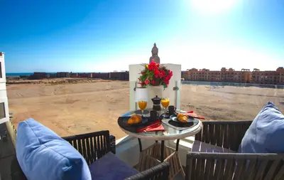 a table on a balcony with a view of the desert at Lavish suite 97m wifi sea view apt boutique resort in Hurghada