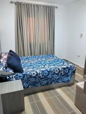 a bedroom with a bed with blue and white sheets at Petite Perle in Port Ghalib