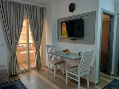 a room with a table and two chairs and a television at Petite Perle in Port Ghalib