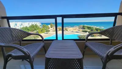 a balcony with chairs and a table and a view of the ocean at Studil for rent old Sheraton 205 in Hurghada