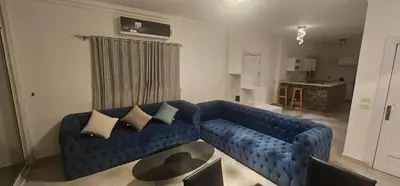 a blue couch with pillows in a living room at Sea view apartment 10 , in city center front of the sea F 10 in Hurghada