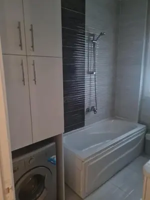 a bathroom with a tub and a washing machine at Sea view apartment 10 , in city center front of the sea F 10 in Hurghada