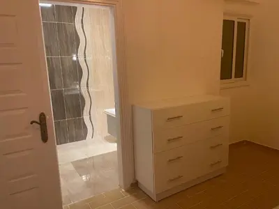 a bathroom with a walk in shower next to a dresser at Sea view apartment 10 , in city center front of the sea F 10 in Hurghada