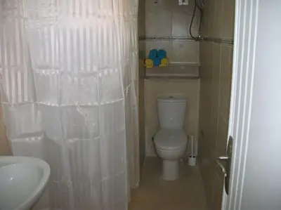 a small bathroom with a toilet and a sink at Desert Rose Apartment in Hurghada
