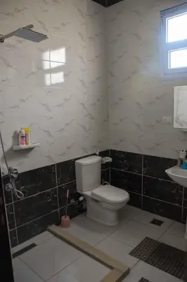 a bathroom with a toilet and a sink at Amenirdis Villa in Al Qurnah