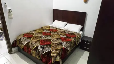 a bed with a comforter and pillows on it at Amenirdis Villa in Al Qurnah