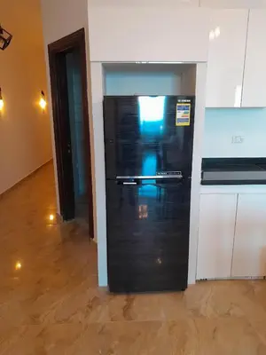 a kitchen with a black refrigerator in a room at Sea view apartment 09 , in city center in front off the sea 09 in Hurghada