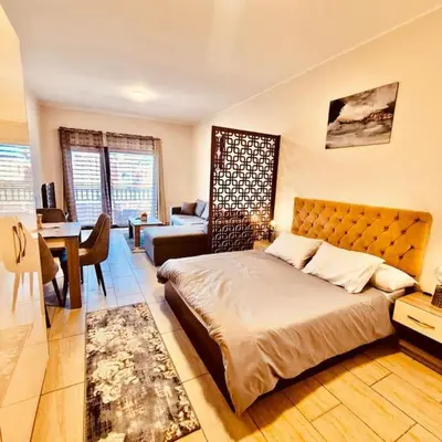 a bedroom with a large bed and a living room at Bosha Aldau Heights Hurghada rent studio in Hurghada