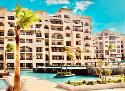 a large building with palm trees in front of it at Bosha Aldau Heights Hurghada rent studio in Hurghada