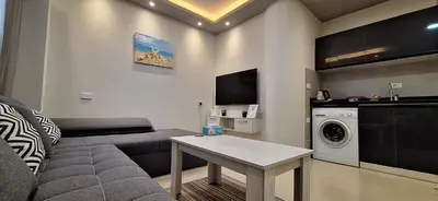 a living room with a couch and a washing machine at Cozy 1BR in Princess Resort with Pools & Private Beach in Hurghada