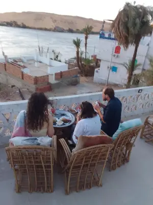 a group of people sitting in chairs at a table at Nubian Life Nile View in Aswan