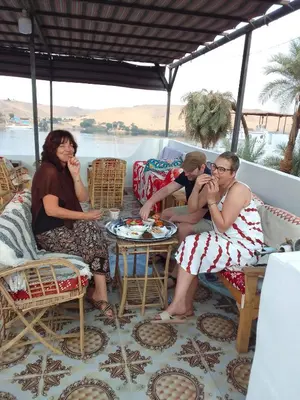 a group of people sitting on a porch at Nubian Life Nile View in Aswan