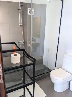 a bathroom with a shower with a toilet and a glass table at Elevated Sea View 2BR Standalone Free Beach & Pool in Somabay in Hurghada