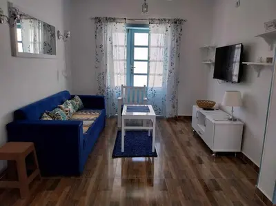 a living room with a blue couch and a table at Ahsaya-house beautiful new home in ‘Ezbet Abu Ḥabashi