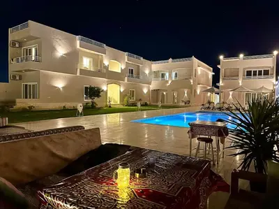 a large house with a swimming pool at night at Royal Nile Suites - Nile View 1 in Luxor