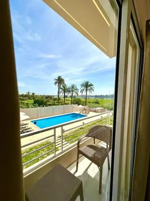 a balcony with a view of a swimming pool at Royal Nile Suites - Luxury Nile View 1 in Al Aqālitah