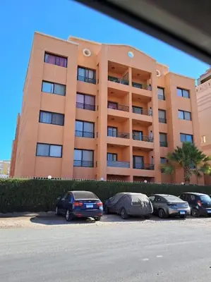 three cars parked in front of a large building at Family Fun -Spacious Apartment in Hurghada