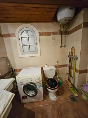 a small bathroom with a washing machine and a toilet at Desert Rose residence 1 bedroom flat in El Kawher in Hurghada