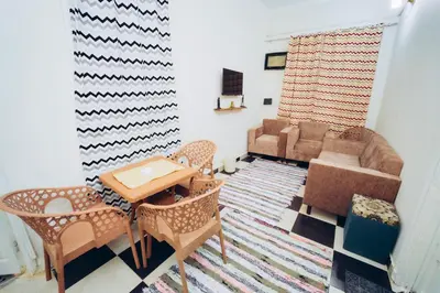 a living room with a couch and a table and chairs at Pharaoh apatrtment in Al Karnak