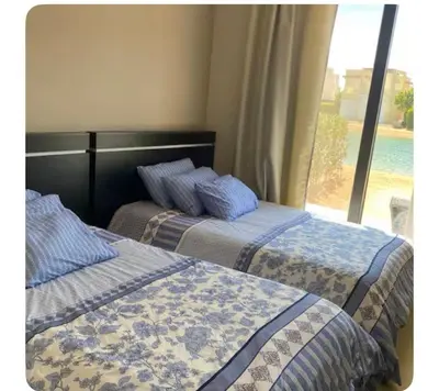 two beds sitting next to each other in a bedroom at lagoon villa in Hurghada