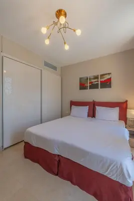 a bedroom with a large bed with a ceiling fan at Elegant 2BR Plus Nanny Room in Mangroovy Gouna in Hurghada