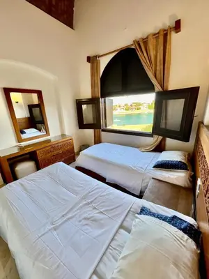 two beds in a room with a window at wast golf y 39-0-2 in Hurghada