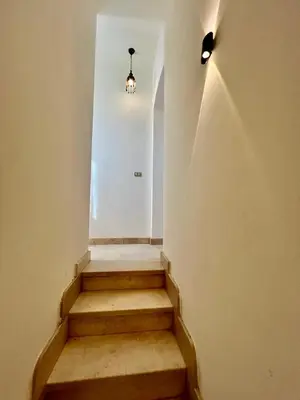 a hallway with stairs with a light and a light fixture at wast golf y 39-0-2 in Hurghada