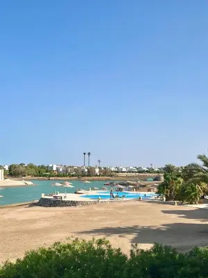 a beach with a group of people in the water at wast golf y 39-0-2 in Hurghada