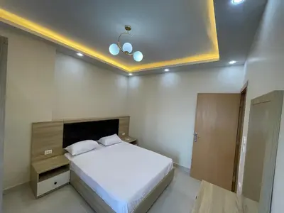 a bedroom with a large white bed and a ceiling at Elamer building in Hurghada
