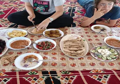 a group of people sitting on the floor with food at The Adventures of Aga Khan in Aswan