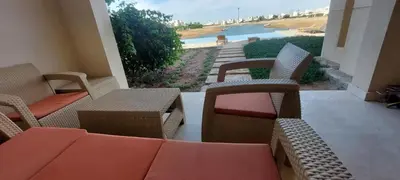 a patio with chairs and tables and a view of the water at Joubal lagoon Elgouna 2BD in Hurghada