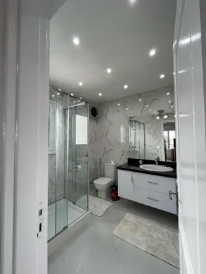 a bathroom with a shower and a toilet and a sink at white villa 4 bedroom elgouna heated pool in Hurghada