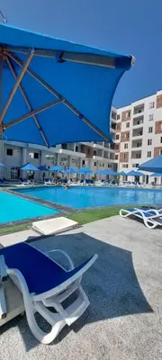 a pool with a blue umbrella and chairs and a swimming pool at Zahabia Golden Beach Resort Down Town in Hurghada