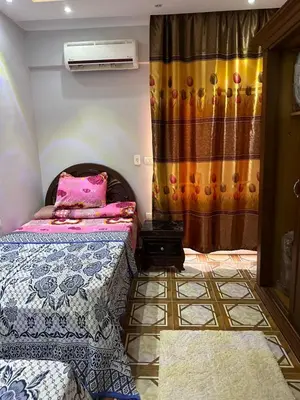 a bedroom with two beds and a window with a heater at Tulip residence villa 1 in Hurghada
