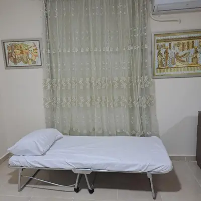 a bed in a room with a curtain at Tiba Golden Beach Resort, Down Town in Hurghada