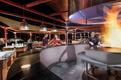 a restaurant with people standing around a bar at Pyramisa Beach Resort Sahl Hasheesh in Hurghada