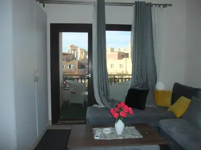 a living room with a couch and a table with flowers at new in Hurghada