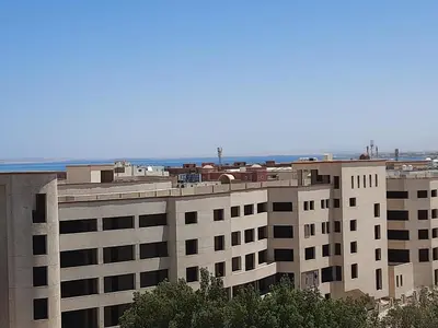 a large apartment building with the ocean in the background at new in Hurghada