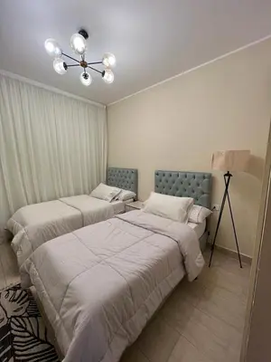 a bedroom with two beds and a lamp in it at Super luxury hotel apartment in Hurghada