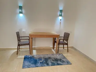 a dining room table with two chairs and a rug at Hadaba Studio in Hurghada